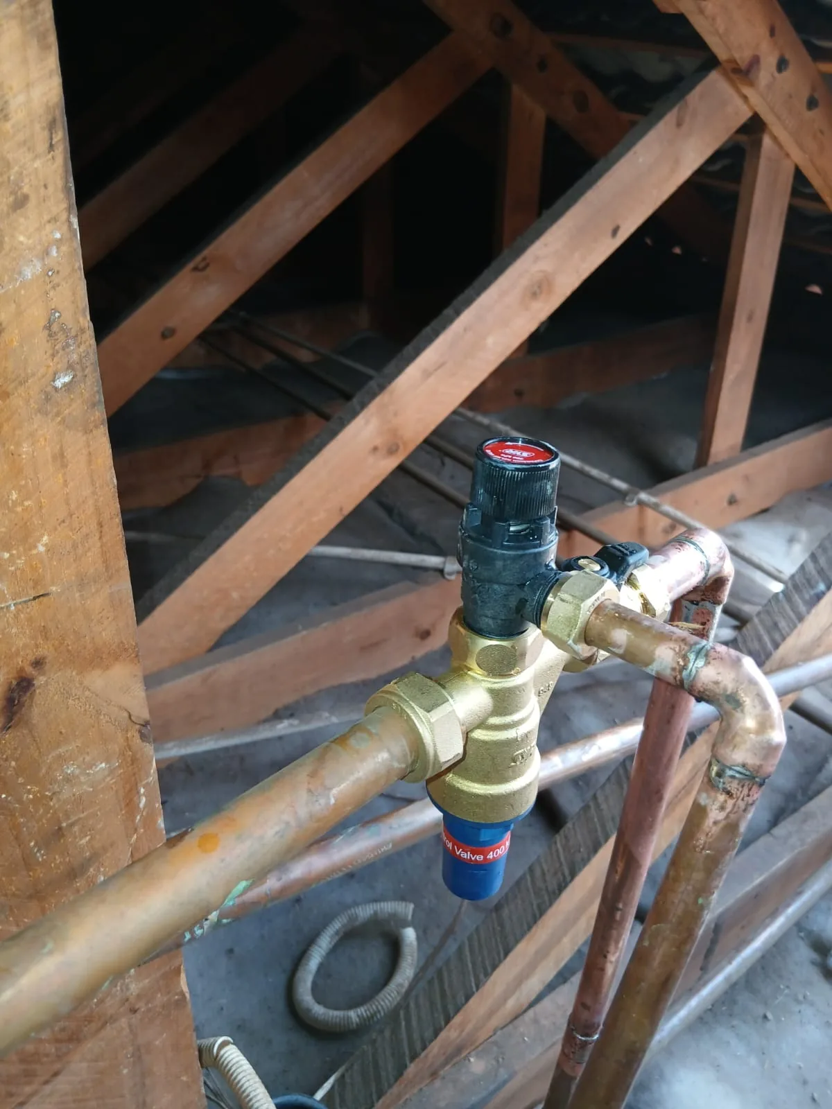 Copper geyser pipework and pressure-control valve work in an Athlone Park roof space