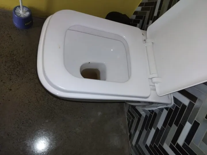 Compact toilet in a narrow tiled bathroom