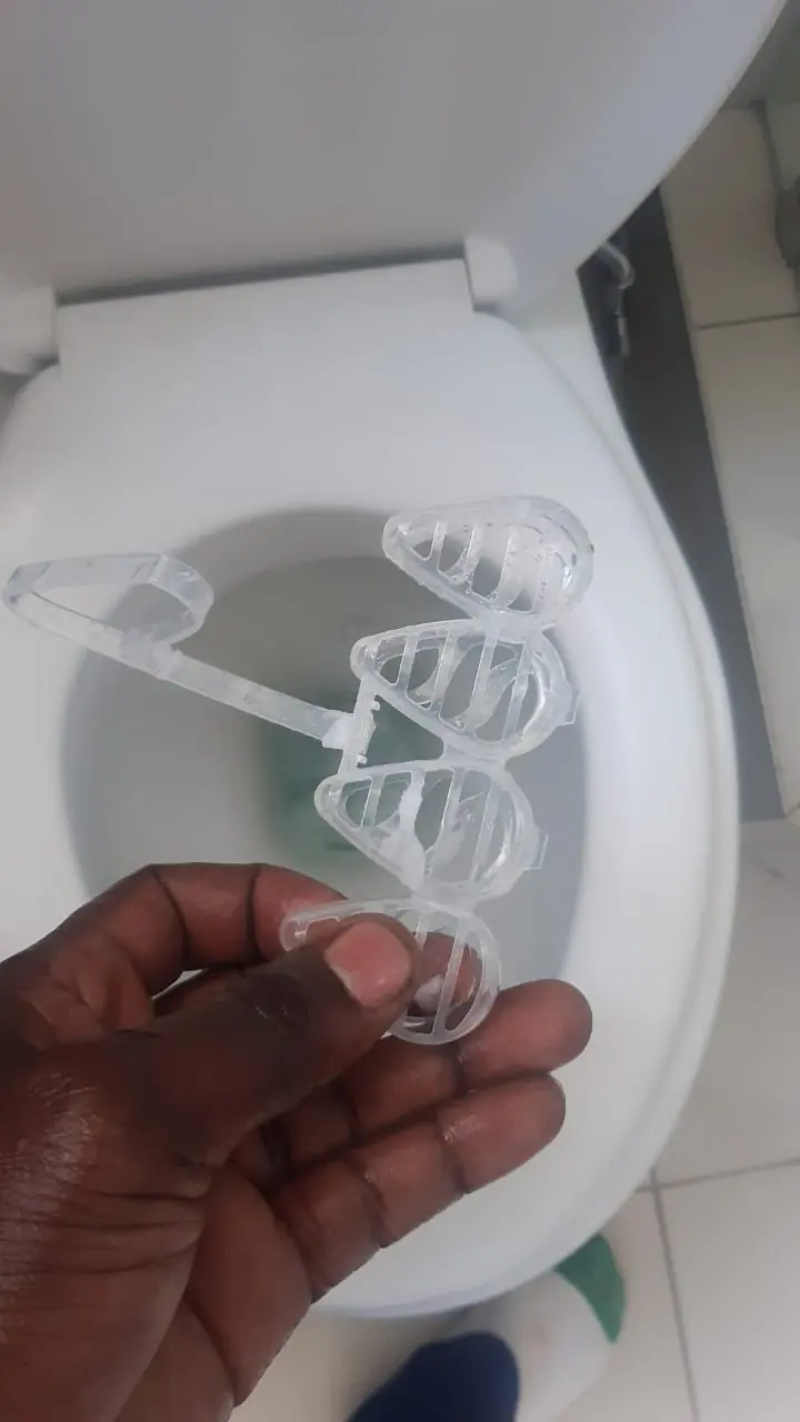 Closed toilet in a small dark cubicle