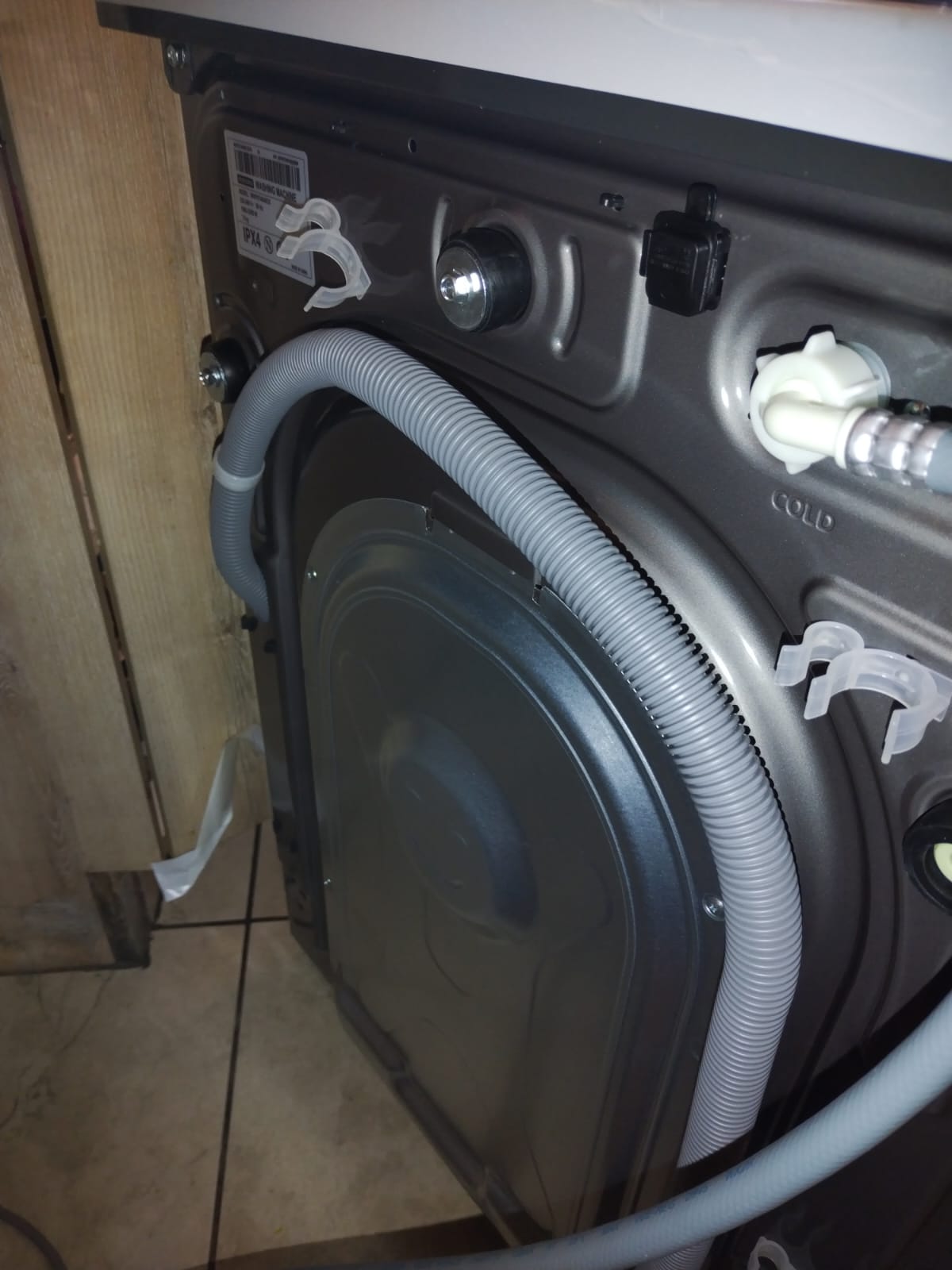 Existing dishwasher valves and waste services on tiled wall