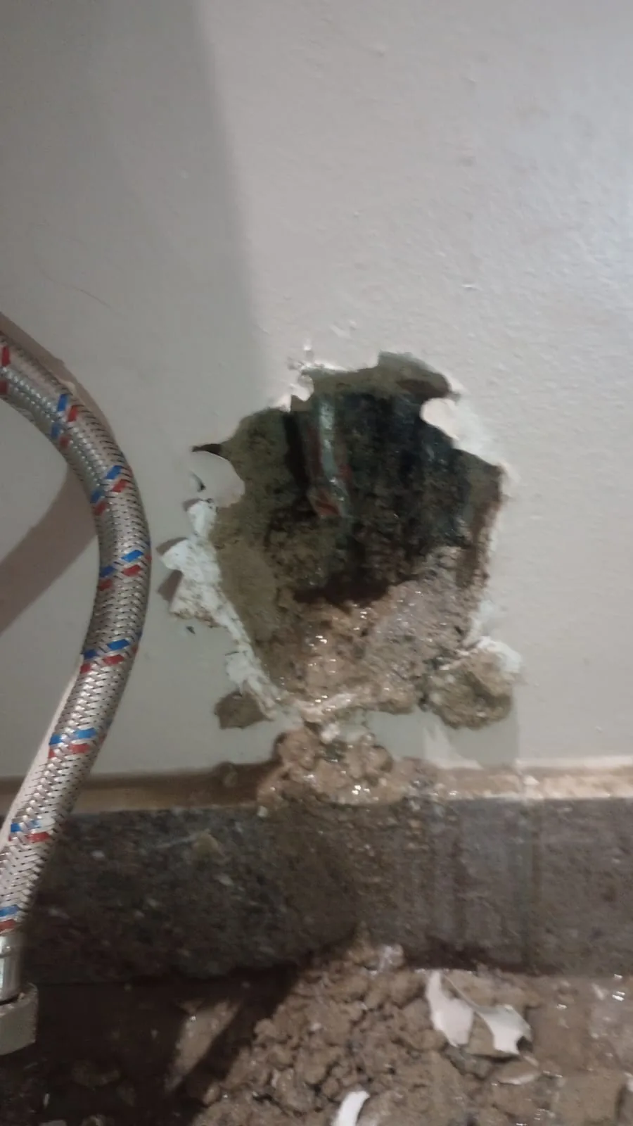 Bathroom wall opened around leaking pipework during pipe repair