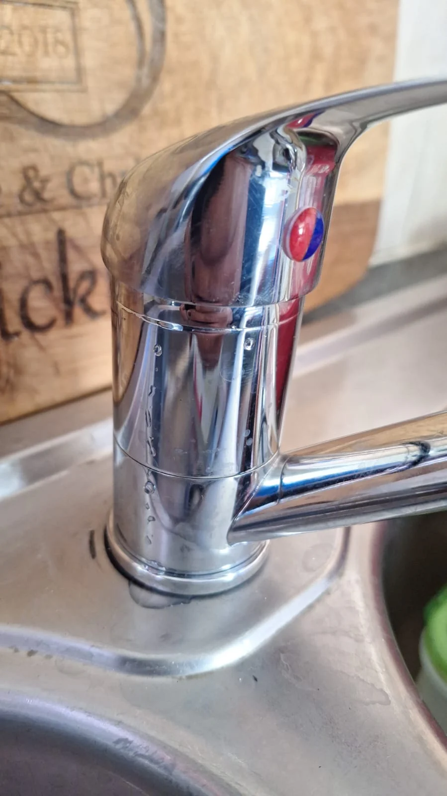 Kitchen sink mixer with visible leak marks around the base