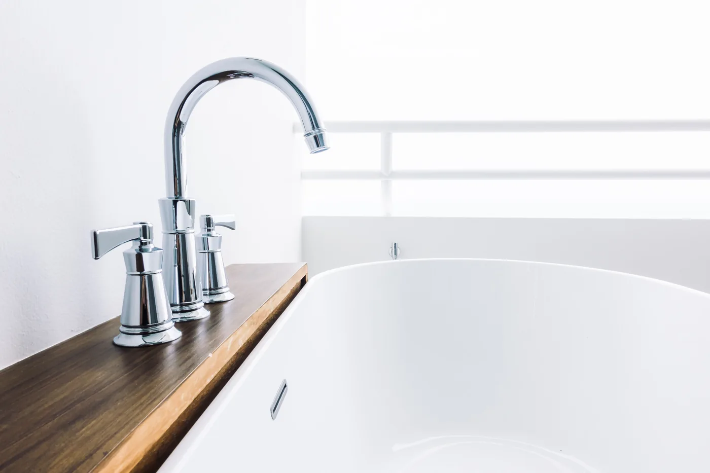 White bath with deck-mounted chrome mixer for plumber in Kempton Park fixture services