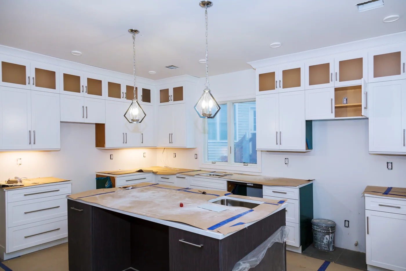 Kitchen renovation layout example Kitchen with white wall cupboards and a dark island during renovation