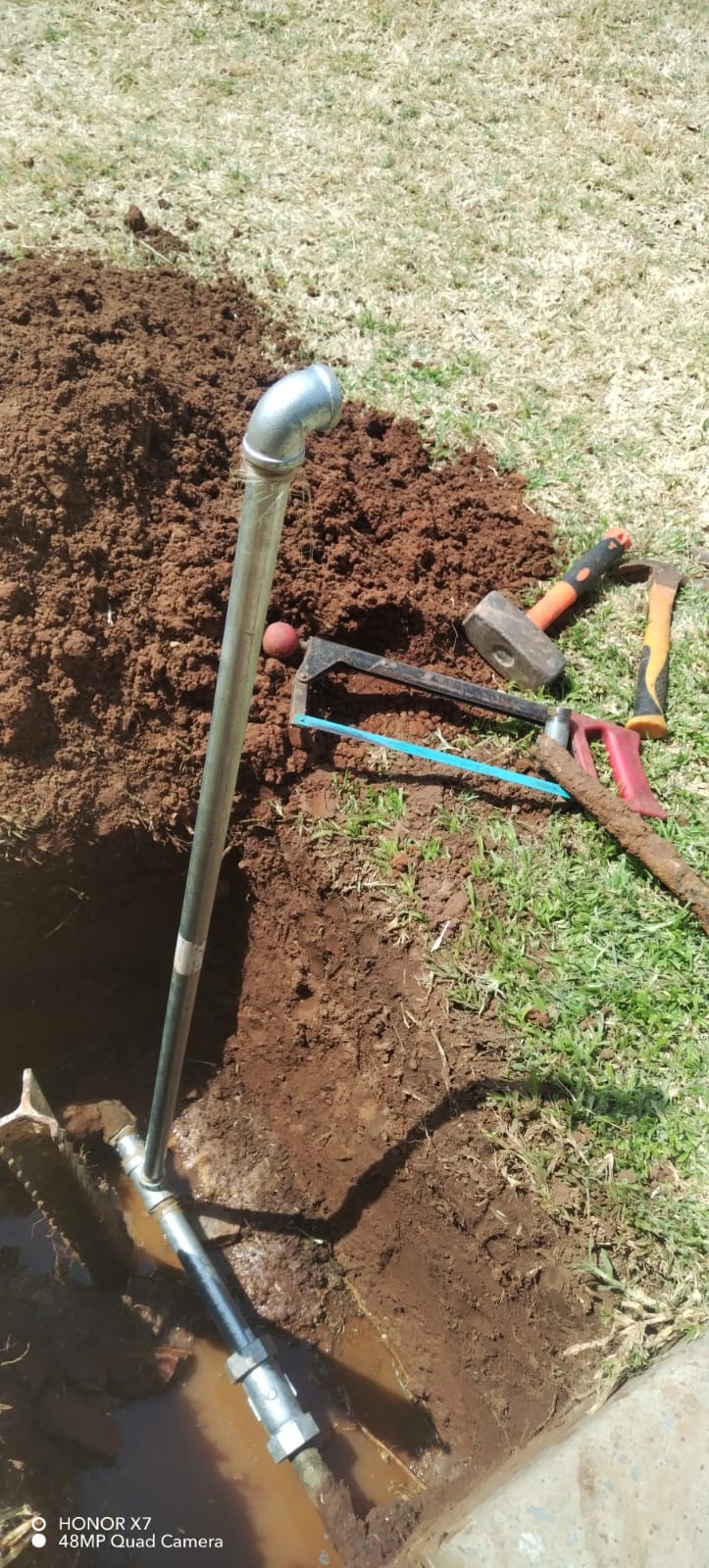 Underground water pipe repair completed in Waterkloof Park with exposed pipework and soil excavation