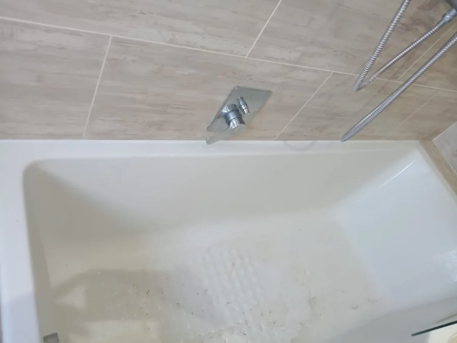 Shower mixer installed above bath during bathroom plumbing work