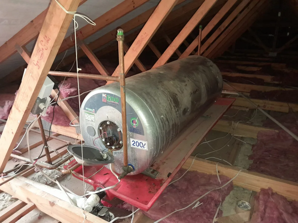 Older geyser in roof space prepared for removal after burst geyser failure