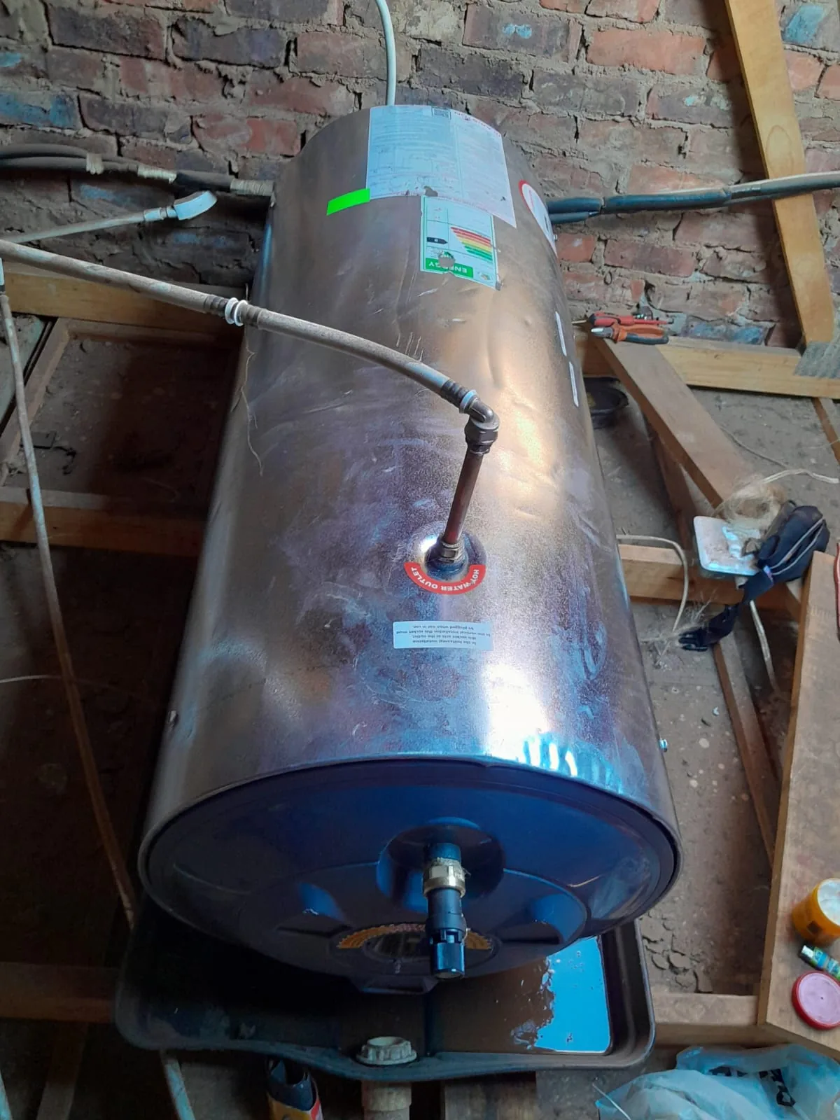 Replacement geyser installed in a utility area with visible pipe connections