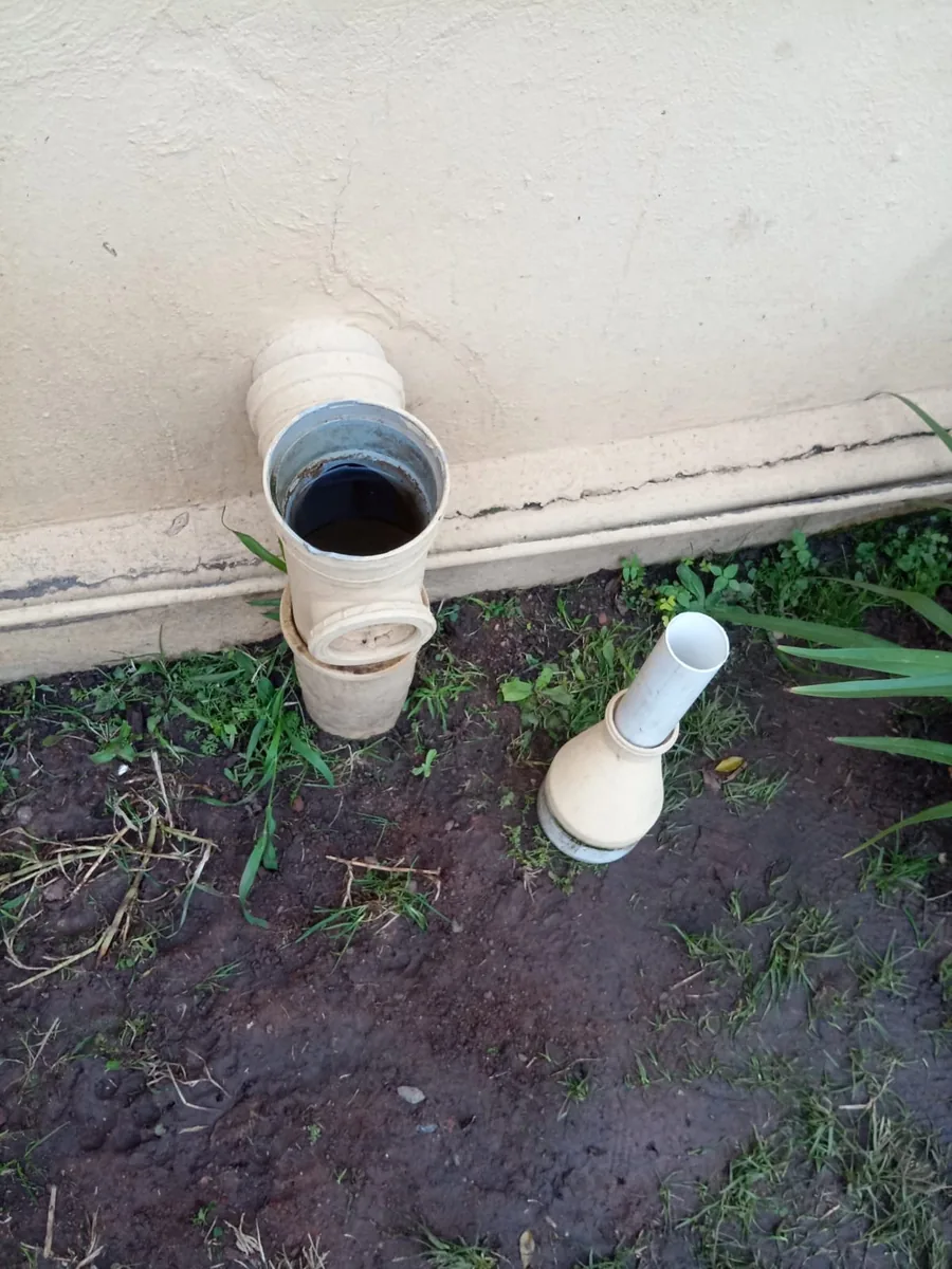 Open sewer inspection point showing dark wastewater in blocked drain line
