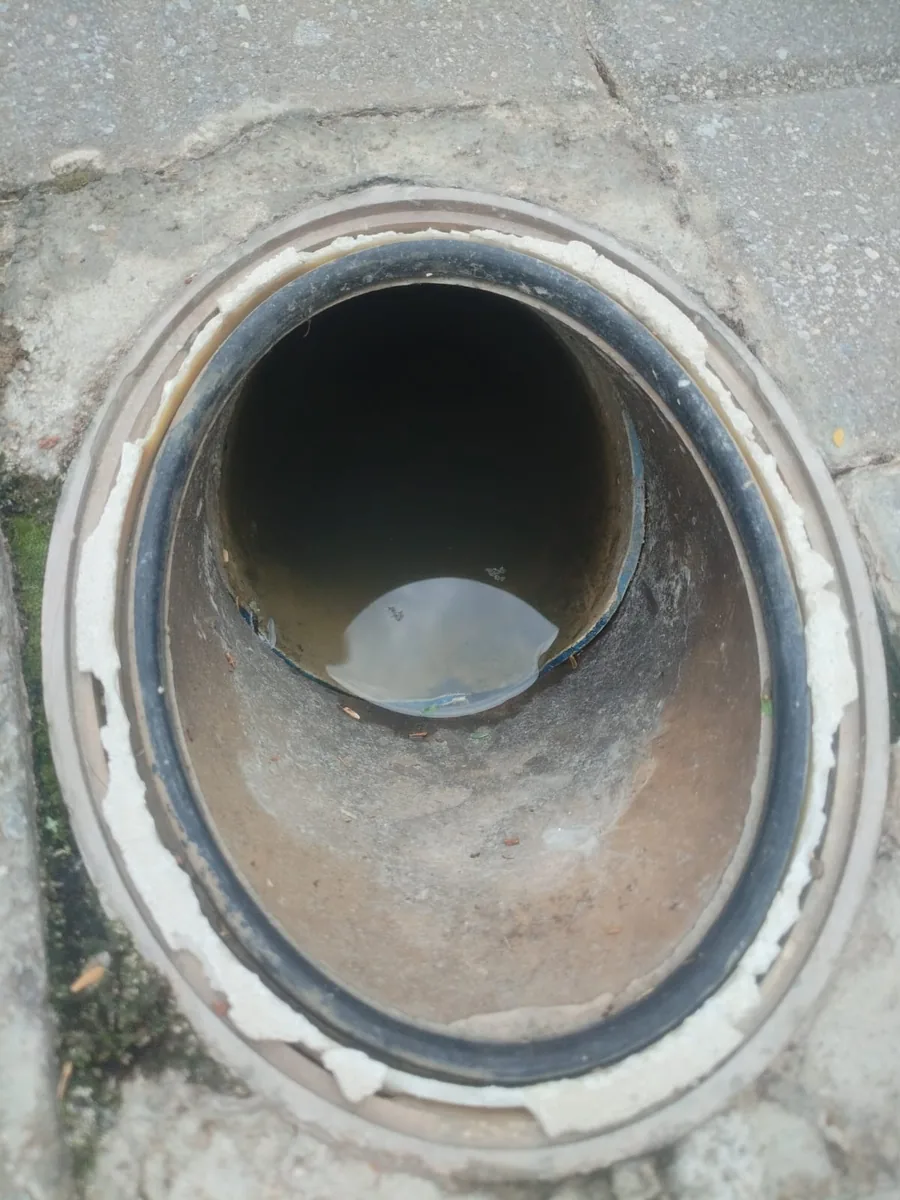 Standing water visible inside a drain opening before clearing