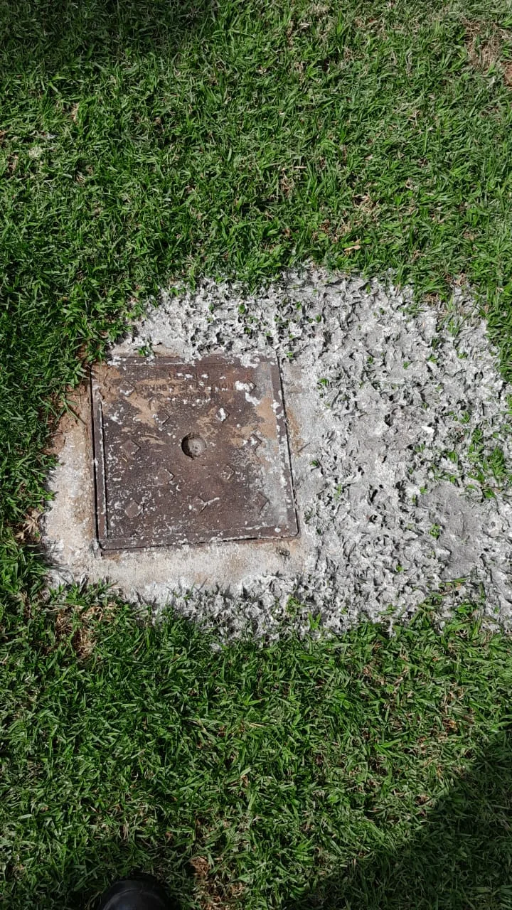 Blocked outside drain overflowing at inspection cover on lawn