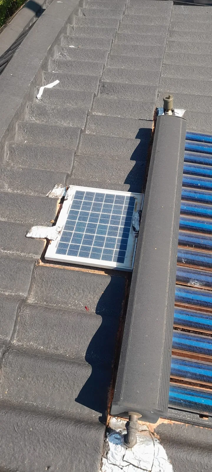 solar geyser controller and collector pipework installed on a tiled roof
