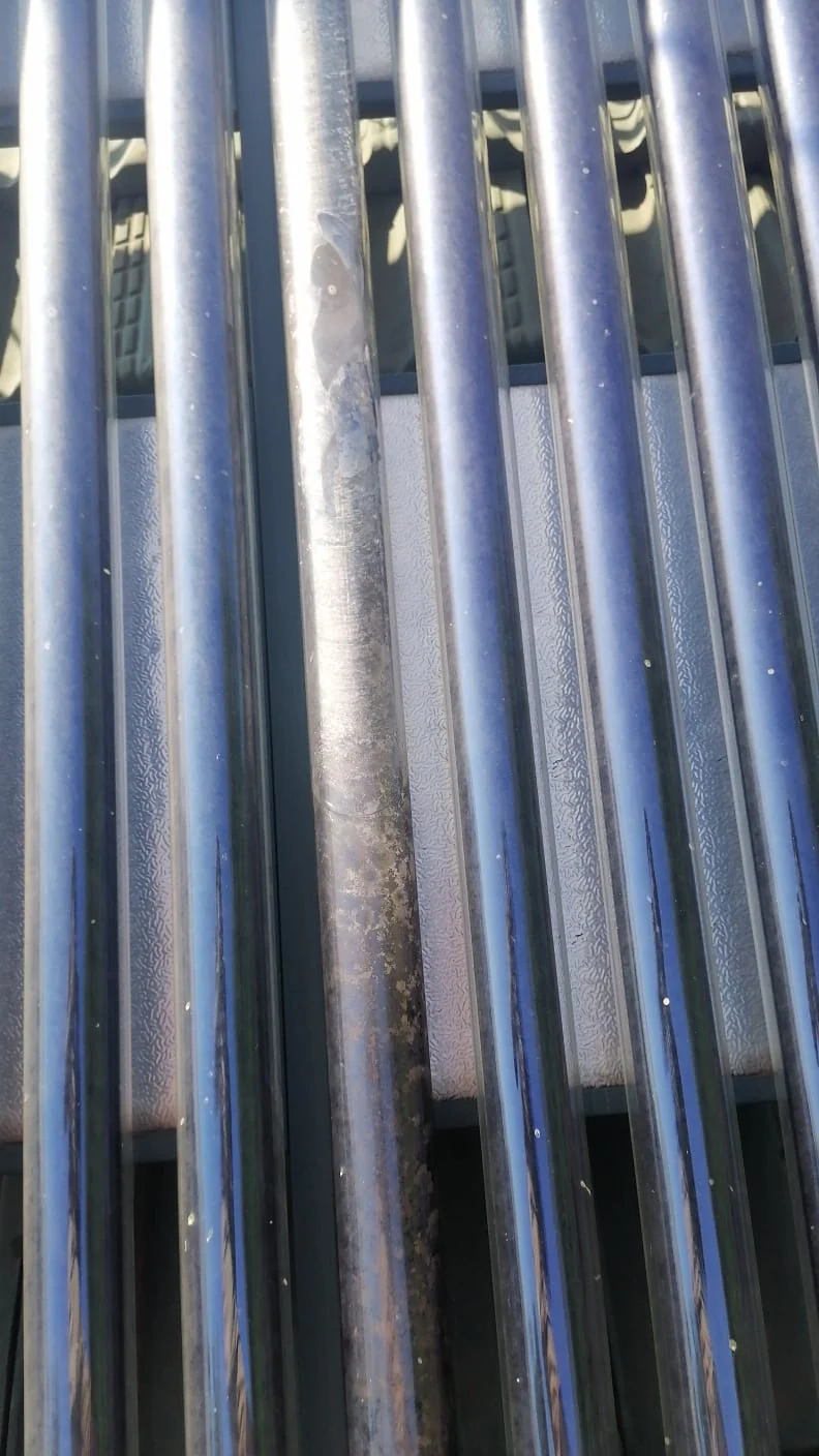 discoloured evacuated solar geyser tube among collector tubes requiring performance check