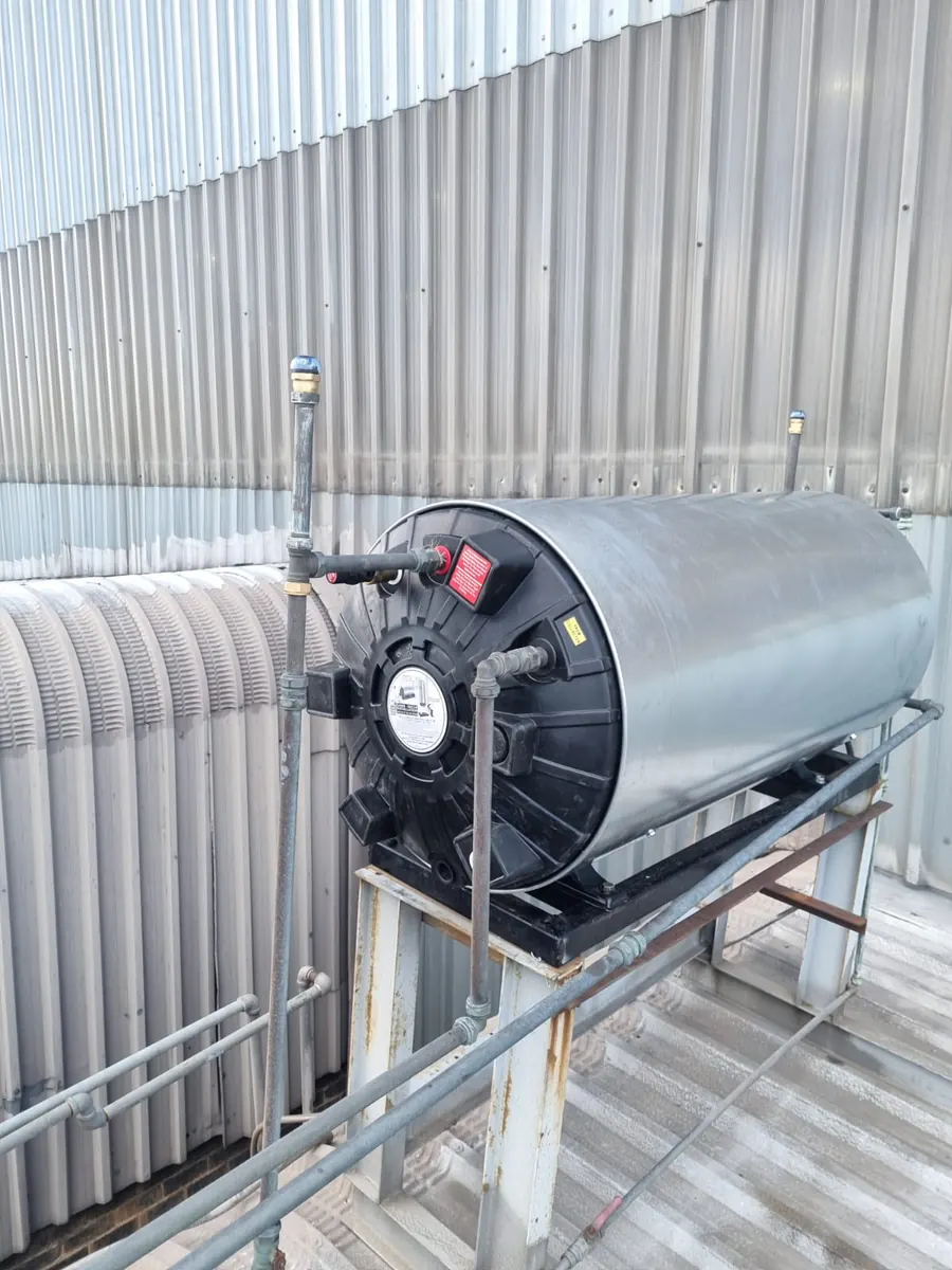 Solar geyser tank end cover with visible cracking near pipework