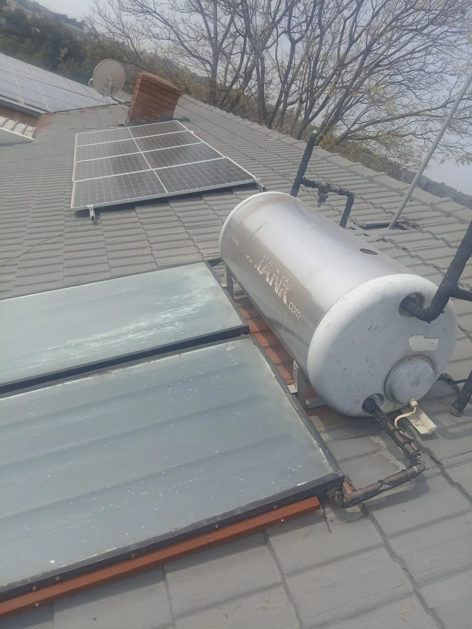 Flat plate solar geyser system installed on tiled roof