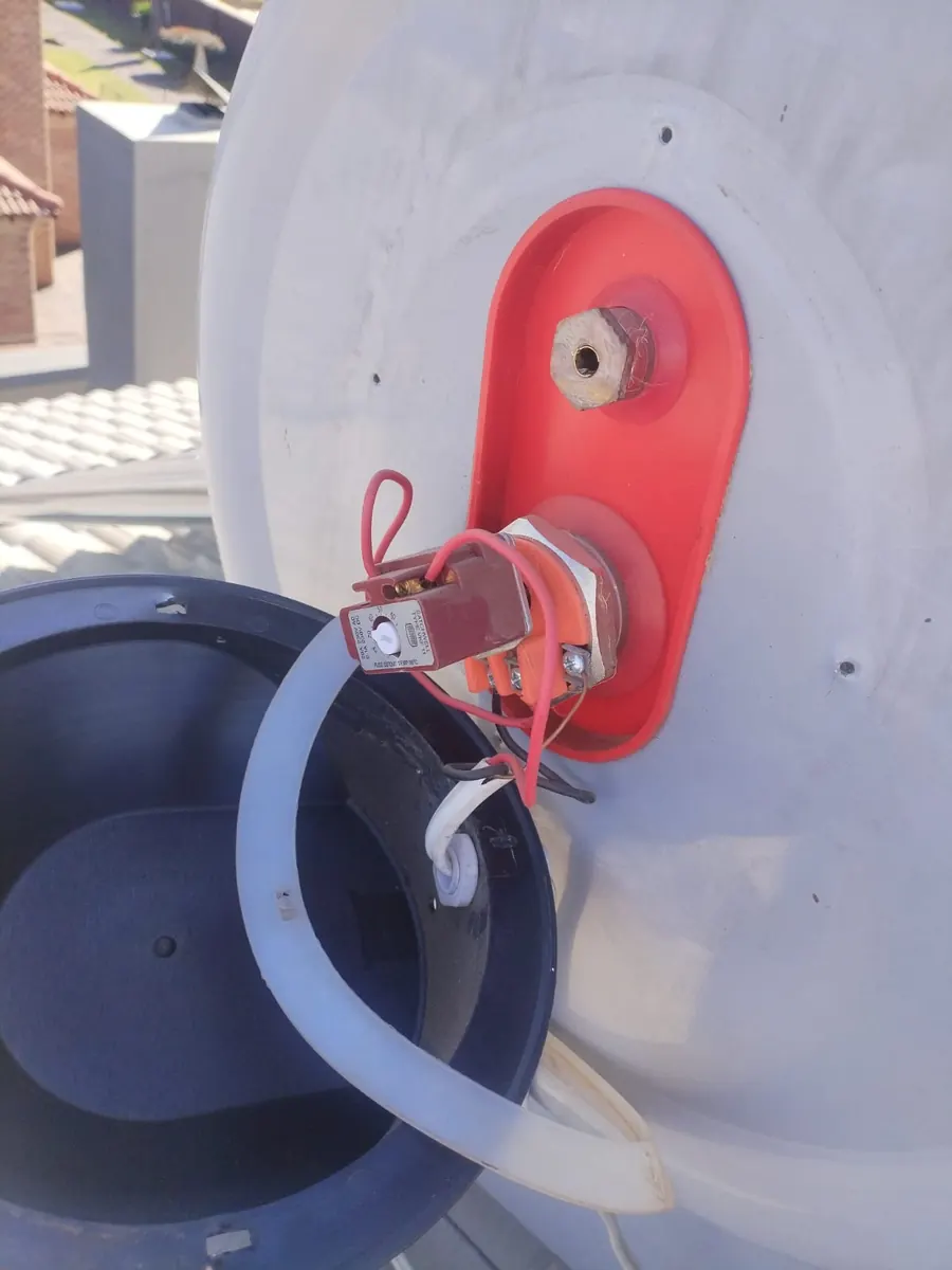 Solar geyser tank and evacuated tube collector with visible water leak on roof