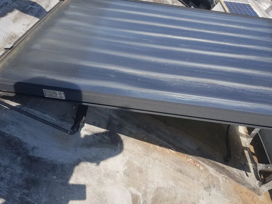 Flat plate solar geyser collector and storage tank mounted on a roof