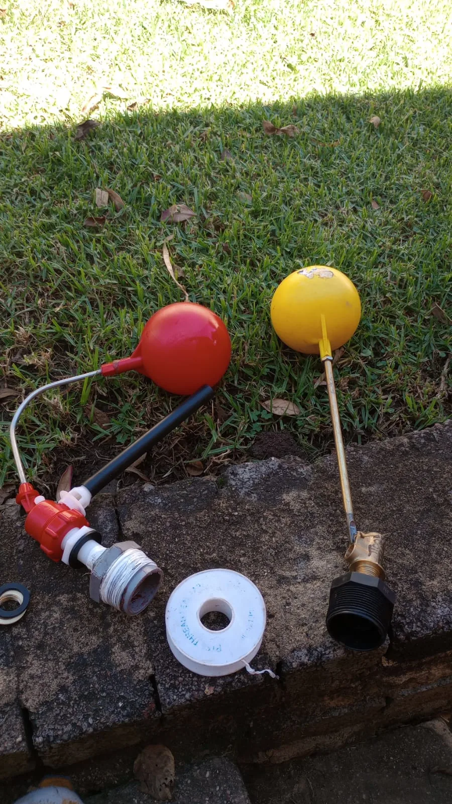 Red and yellow toilet float valve parts placed on grass