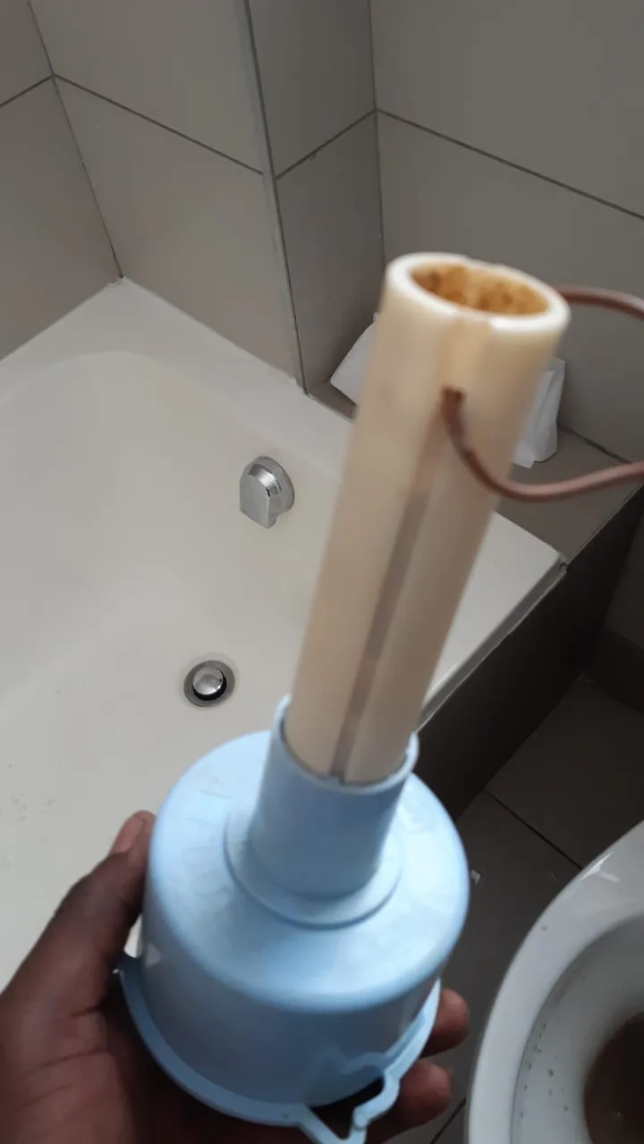 Removed toilet flush valve part held above toilet pan