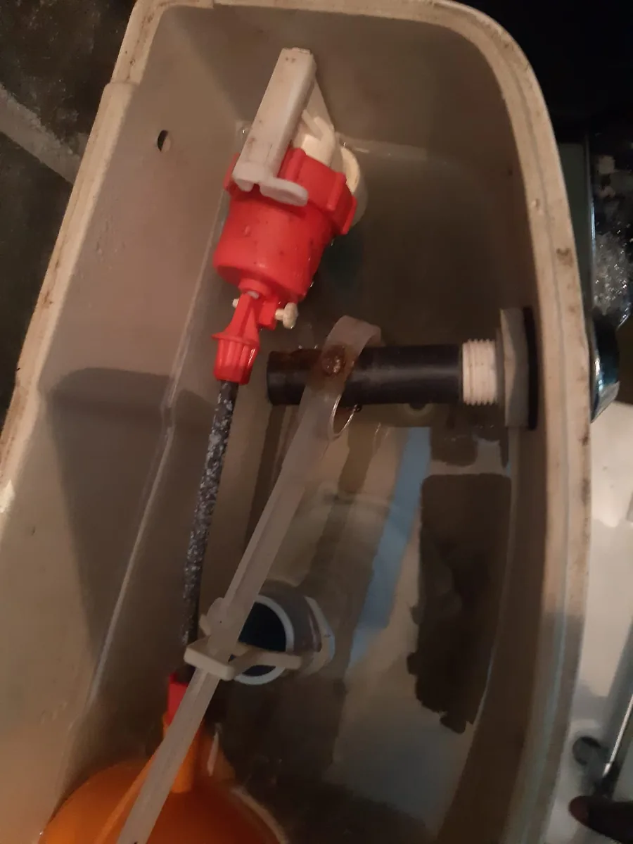 Open toilet cistern showing side-entry fill valve and float arm