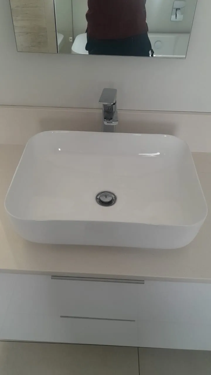 White bathroom basin and vanity with visible drain outlet