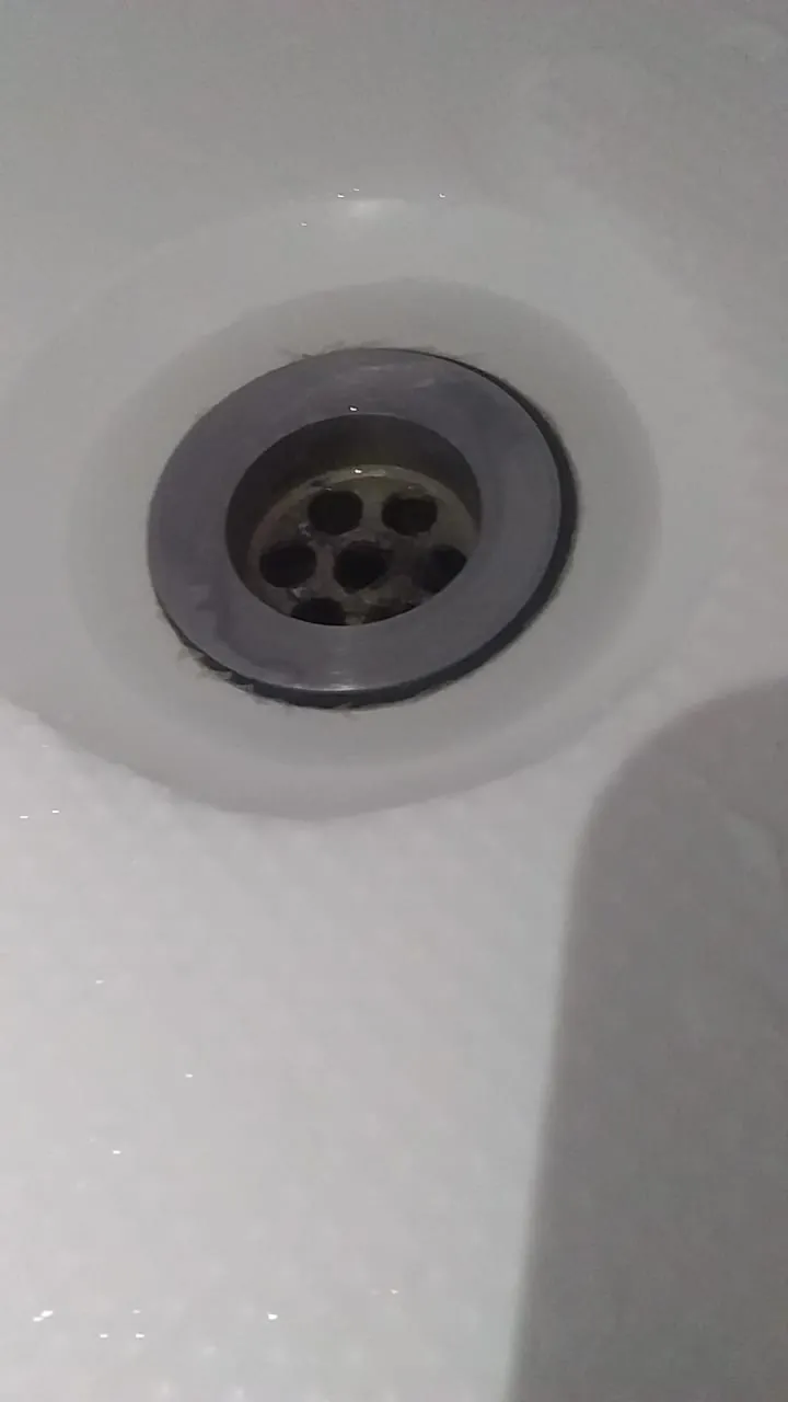 Close-up of a basin waste outlet inside a white basin
