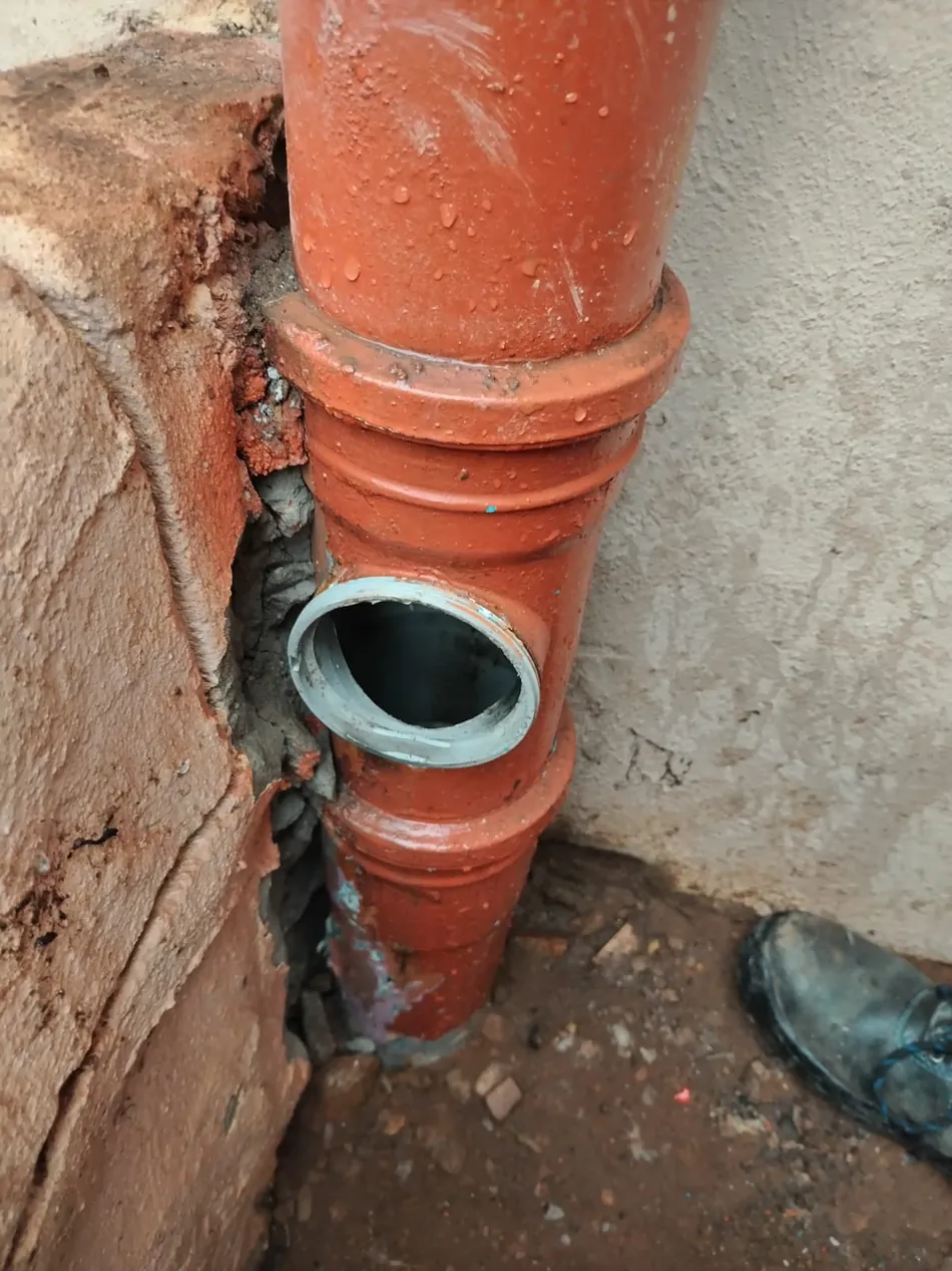 Orange sewer pipe cleaning eye opened on an outside wall
