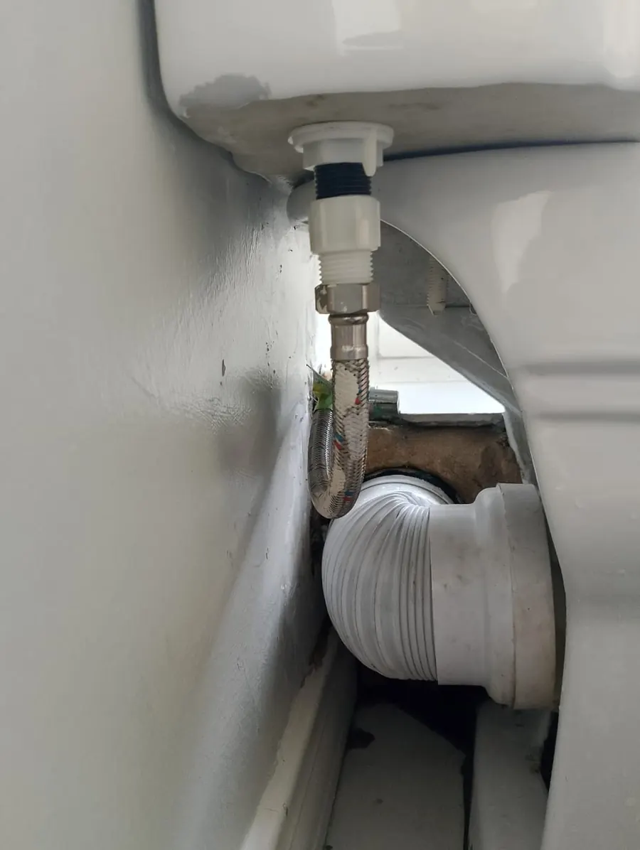 Close-up of chrome toilet flush button on cistern lid