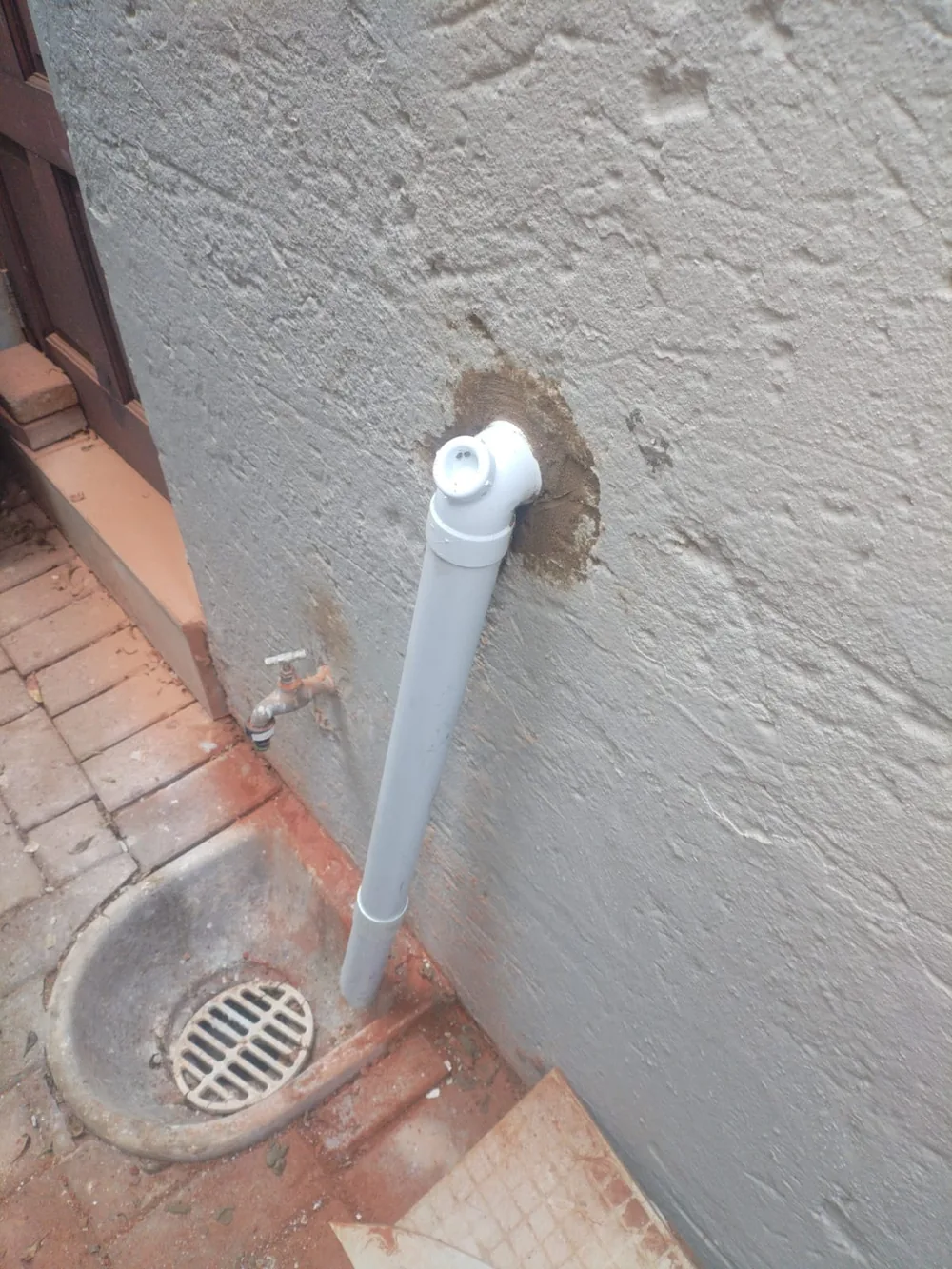 Outside drain overflowing with wastewater during emergency blocked drain cleaning