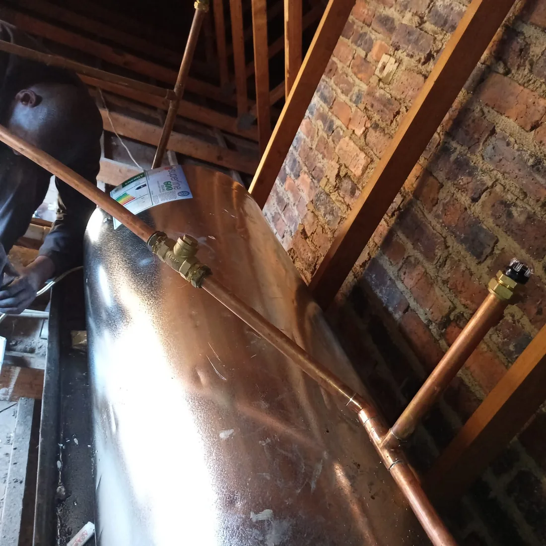 Roof space geyser installation with copper pipework and safety fittings in Zandvlei
