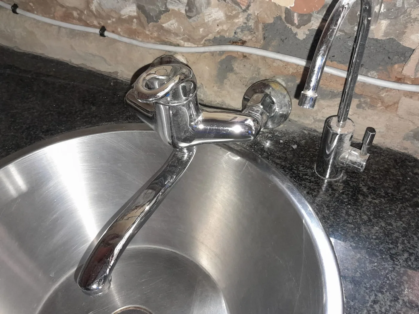 Wall mounted kitchen sink mixer repair above a stainless steel sink in Zandvlei