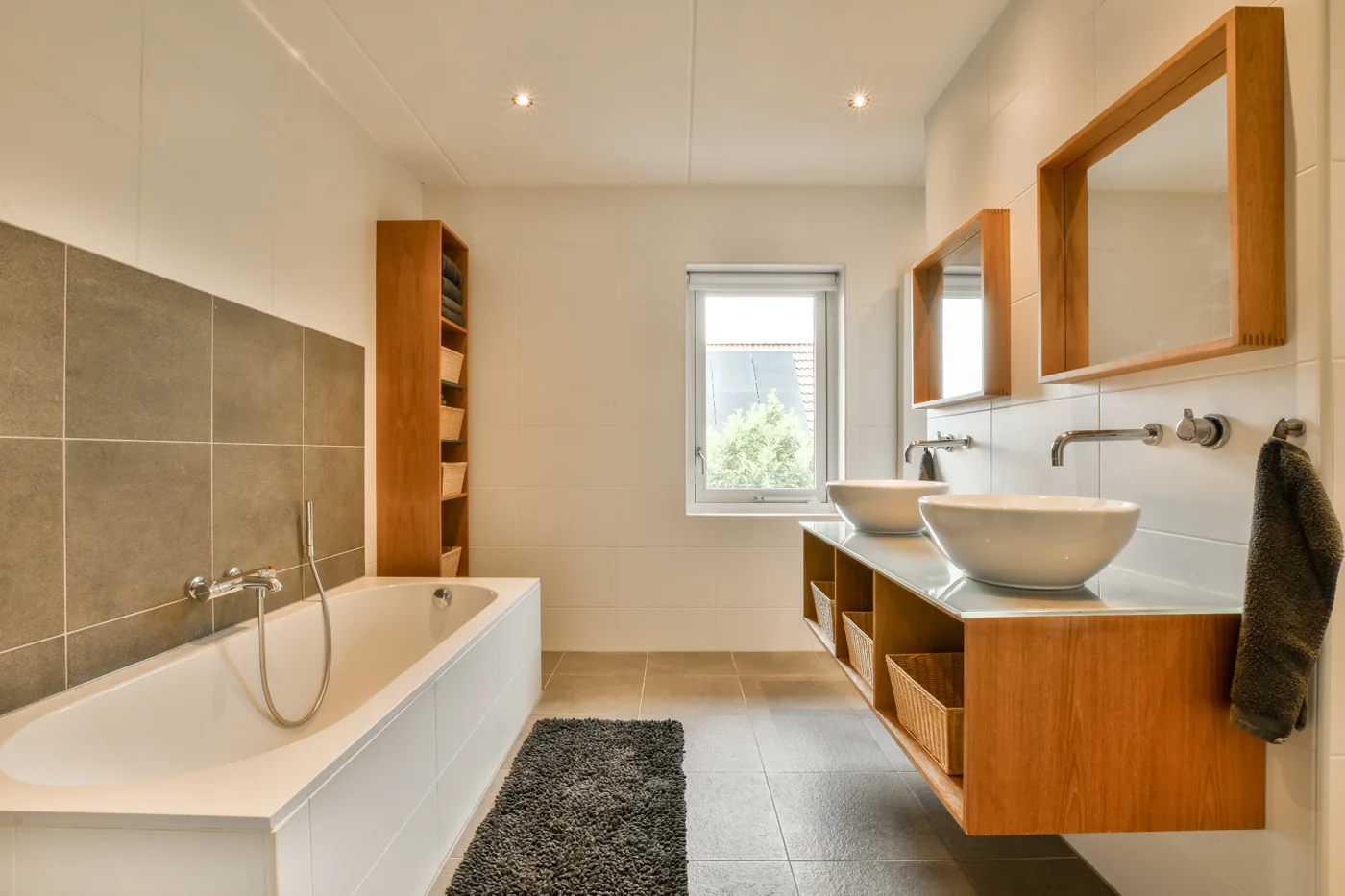 Complete bathroom renovations design inspiration with wood cabinetry, a white bath and basin