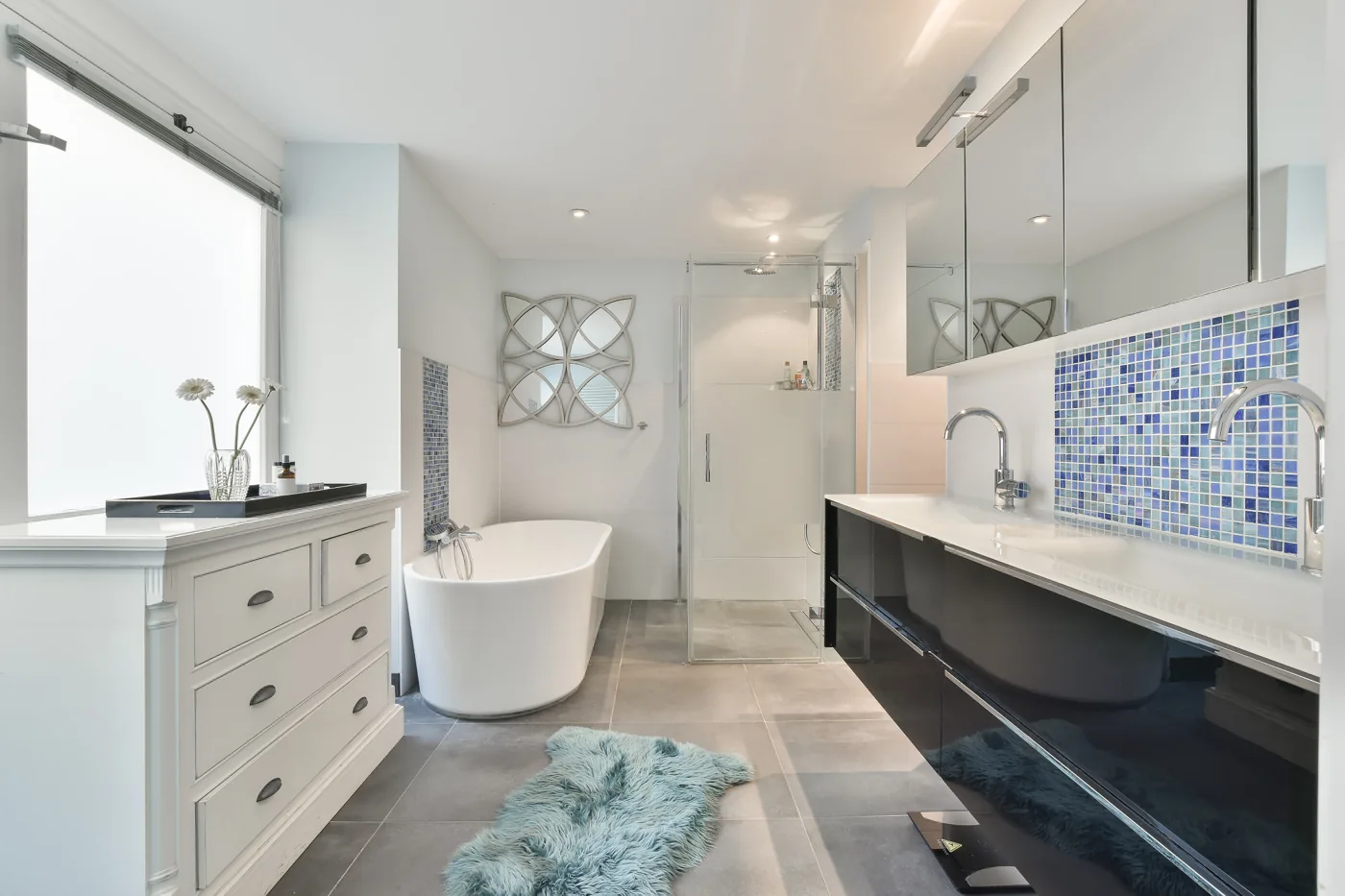 Luxury bathroom renovations inspiration with marble-look walls, a freestanding bath and vanity