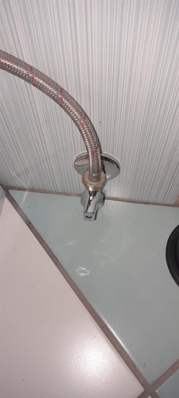 Leaking toilet shutoff valve with visible water