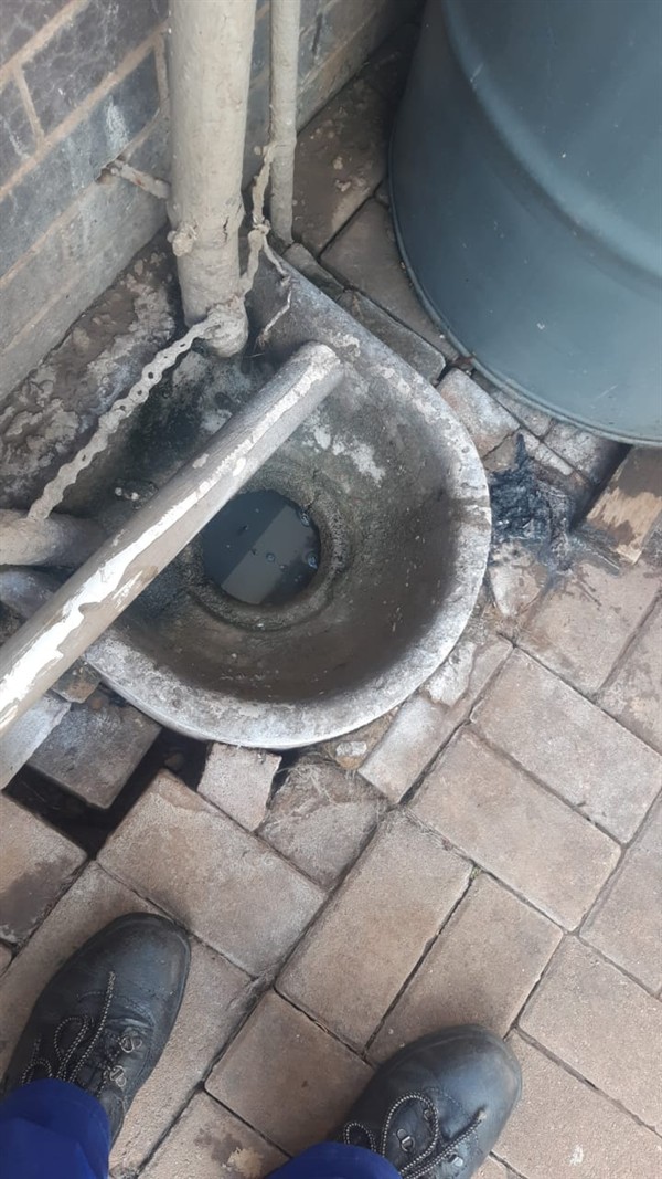Fully blocked drain filled with water that refuses to flow away