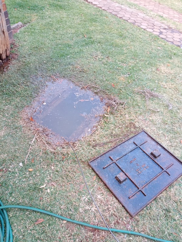 Close-up of blocked drain with standing dirty water and slow flow in Botesdal