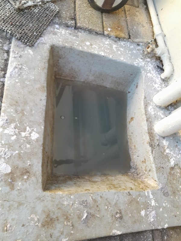 Plumber clearing a blocked drain pipe using professional tools