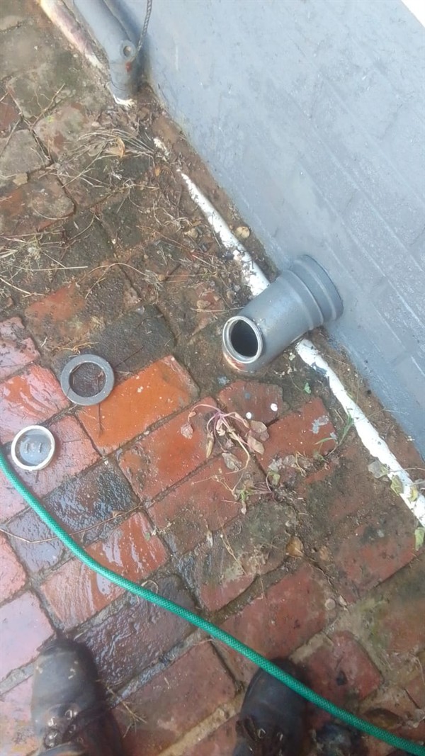 Hands performing repair on blocked sewer pipe