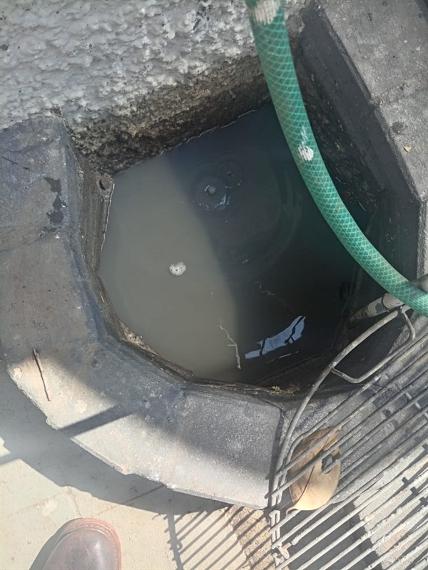 Plumber clearing a blocked drain pipe using professional tools