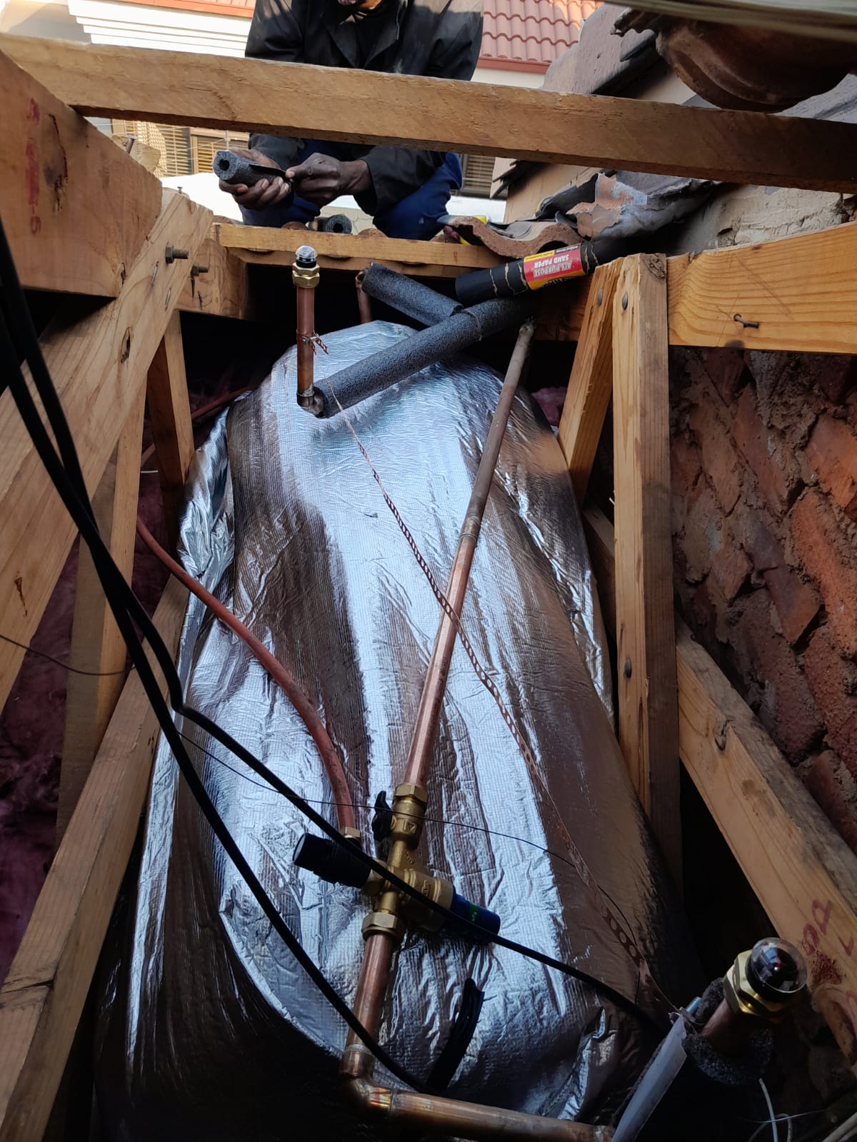 New geyser installed in roof space in Bedfordview with insulated piping, safety valve, and copper connections, showing burst geyser replacement and professional installation to restore reliable hot water supply and ensure safe system operation.