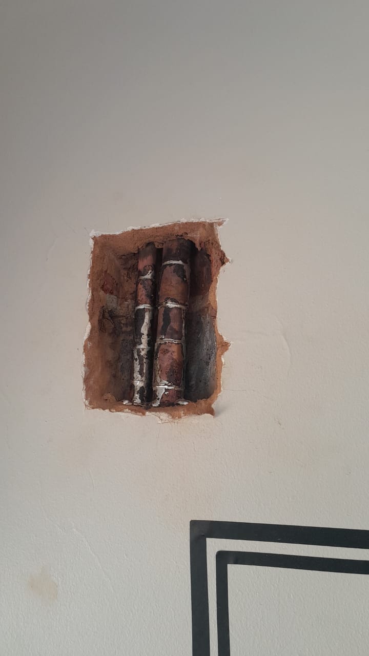 Burst pipe in wall repaired in Blairgowrie, showing exposed copper water pipes inside wall cavity after repairing leak and restoring proper water supply.