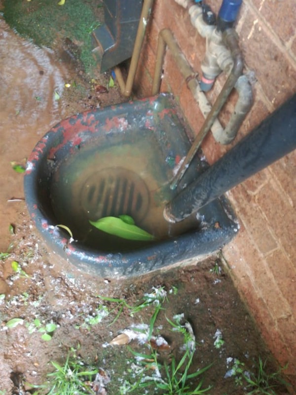 Hands performing repair on a blocked drain