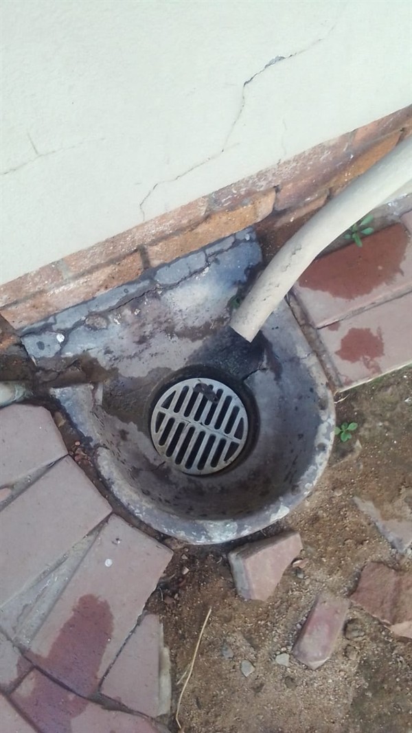 Blocked drain trap with debris visible