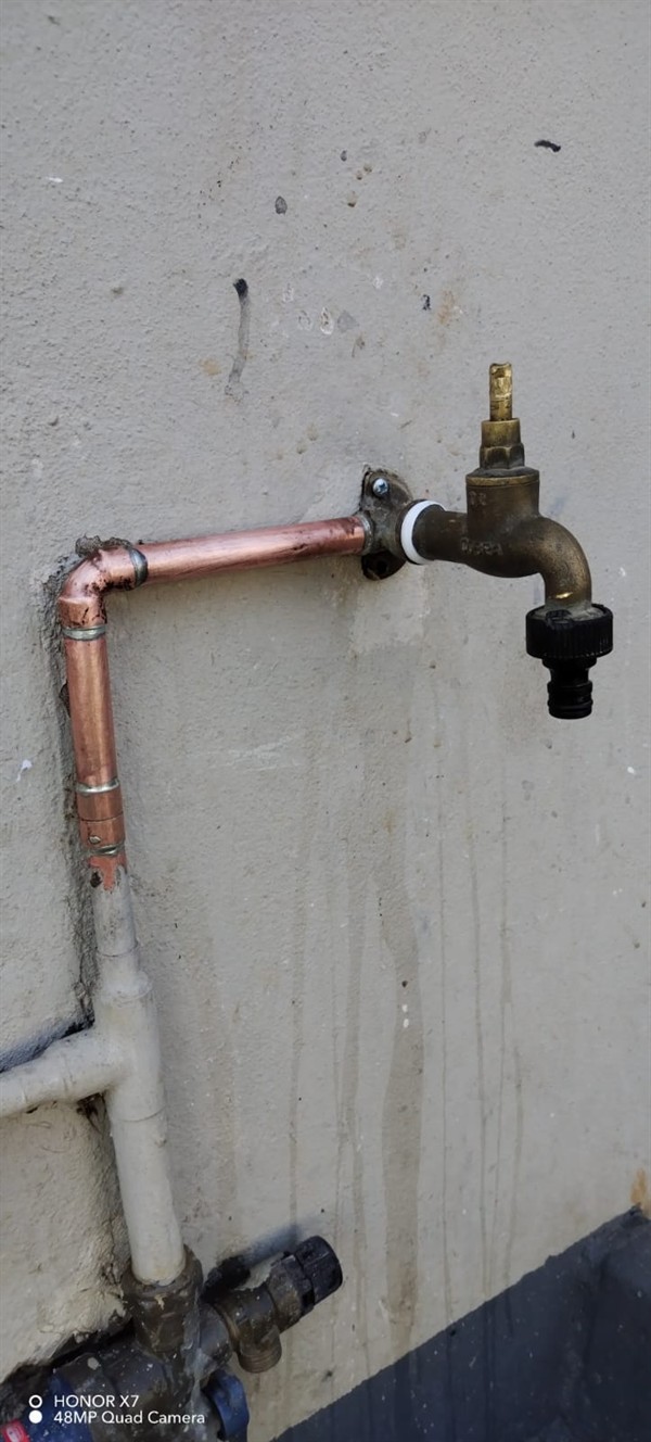 Running water soaking ground from burst outside pipe in Lanseria