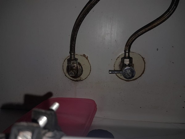 Leaking stop valve at basin connection with water accumulation