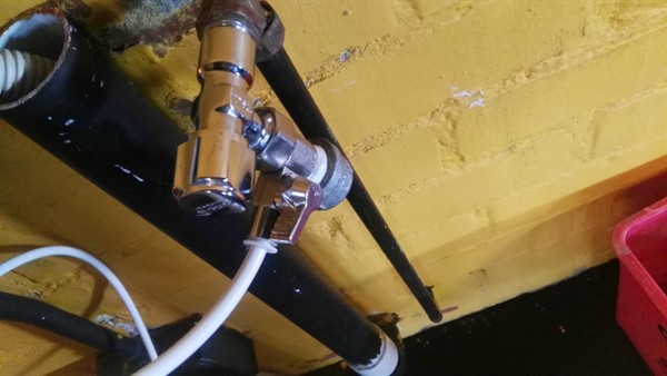 Leaking angle stop valve on washing machine pipe showing water marks