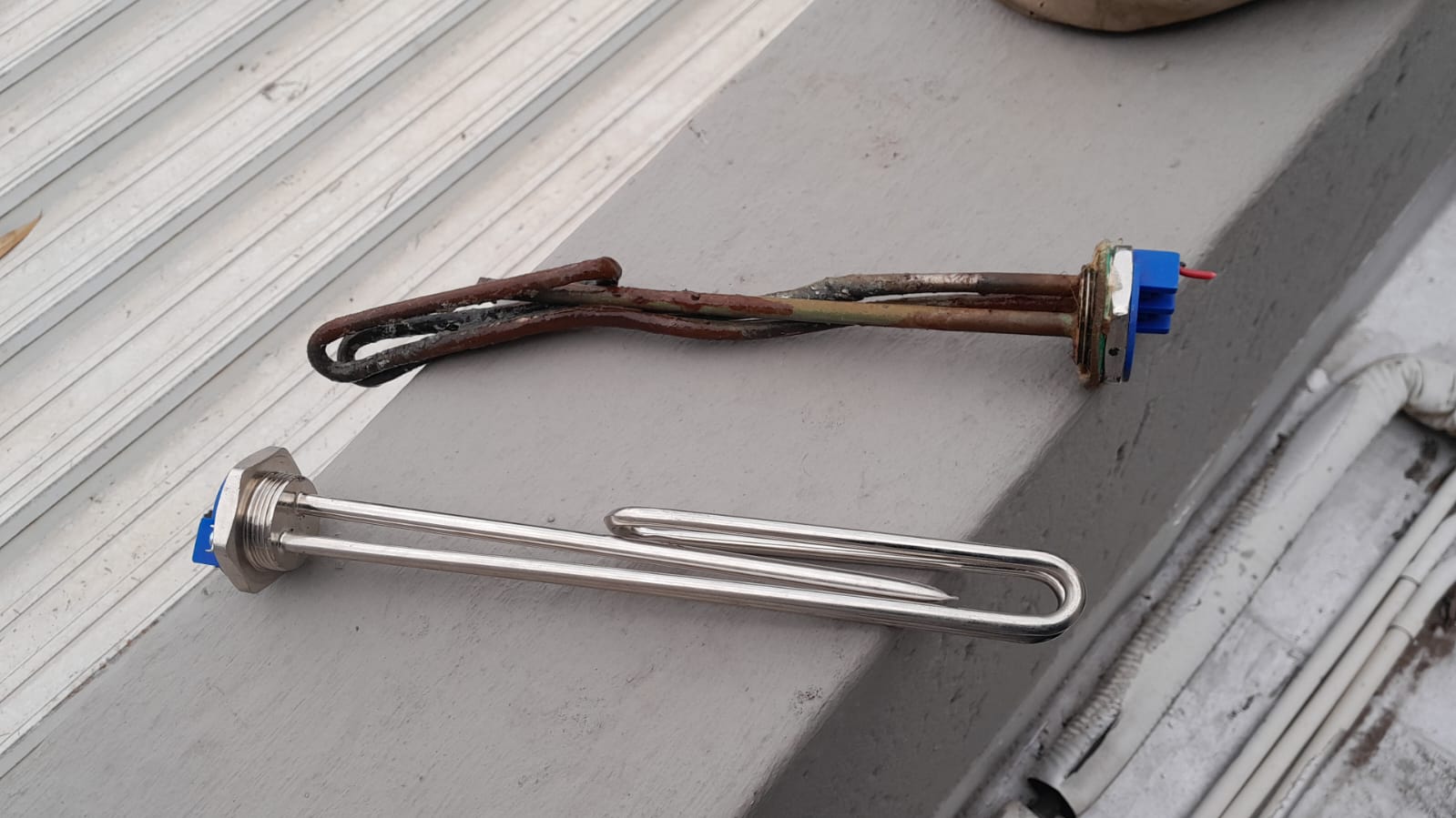 Faulty geyser heating element removed and new replacement element shown side by side in Primrose, highlighting burnt and damaged old element replaced to restore proper hot water heating and improve geyser performance.