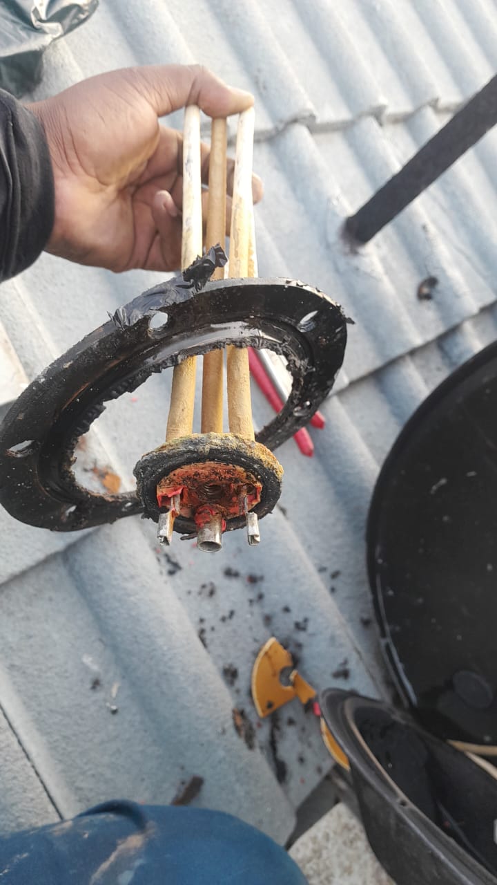 Faulty solar geyser heating element removed in Glen Marais showing corroded element assembly on roof during solar geyser repair and element replacement.