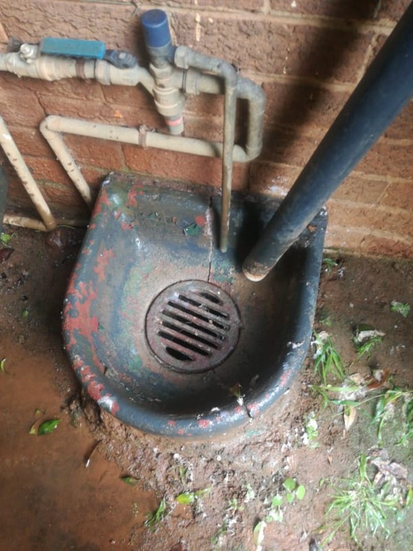 Completely blocked gulley with dirty standing water