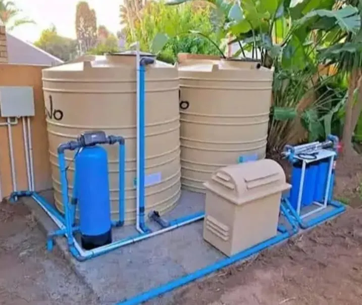 JoJo Tank Filtration Installation JoJo tank filtration system with storage tanks, pump, blue pipework and filters installed outside a home